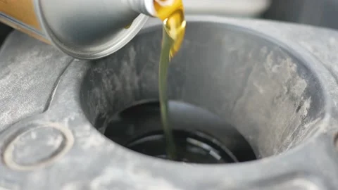 Engine oil is poured into the engine. Oil flows slow motion Stock Footage 143853890