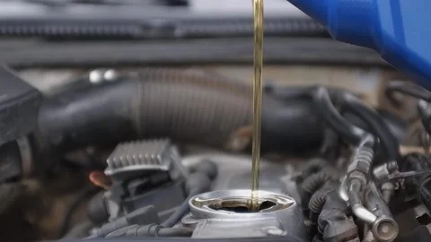 Engine oil pours from the canister into the engine.Refueling with fresh engine o Stock Footage 165127469
