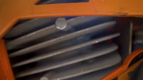 The engine of the orange chainsaw on top of the woods Stock Footage 133389707