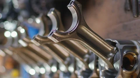 Engine pistons with connecting rods stand in a row. The camera focuses on them. Stock-Footage 240720173
