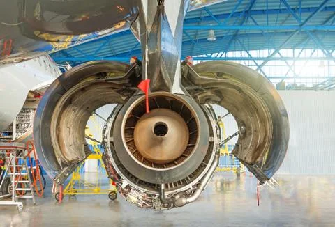 Engine planes with open hood flaps on maintenance in a hangar. Rear view, noz Foto stock