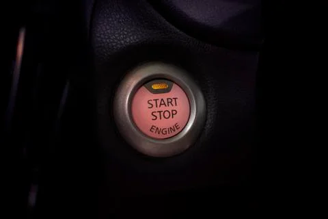 Engine start button of car with a orange light. Stock Photos