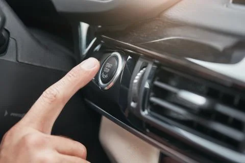 Engine starting. Cropped image of a hand pushing on the start and stop button of Foto stock