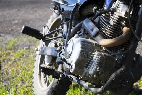 The engine of a subcompact motorcycle is a close-up parked on a green lawn. Stock Photos