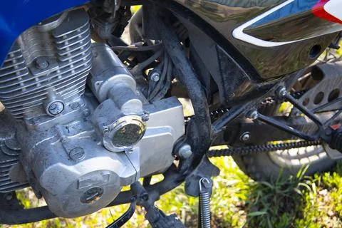 The engine of a subcompact motorcycle is a close-up parked on a green lawn. Stock Photos