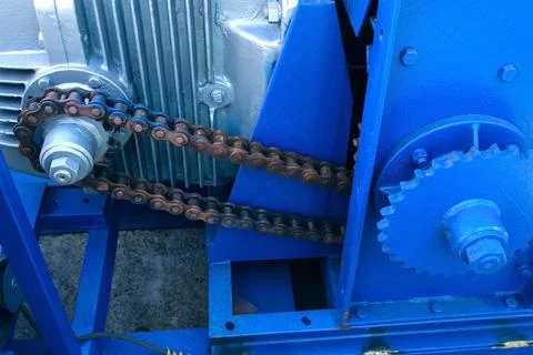 Engine of woodworking machine with chain rotating between gear wheels on plant. Foto stock