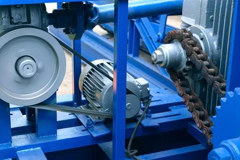 Engine of woodworking machine with chain rotating between gear wheels on plant. 写真素材