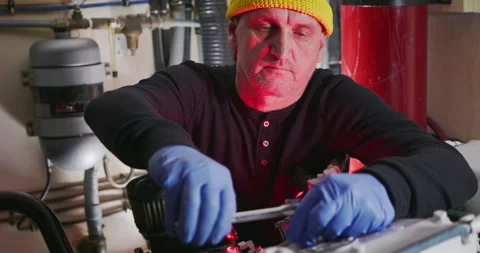 Engineer Adjusting Equipment in Industrial Engine Room Stock Footage 323736893
