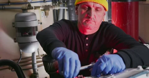 Engineer Adjusting Equipment in Industrial Engine Room Stock Footage 323737314