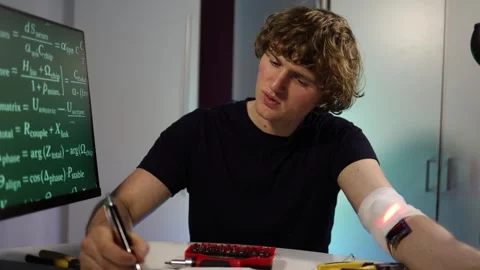 Engineer adjusting glowing arm implant while working with neural algorithms in h Stock Footage 324443330