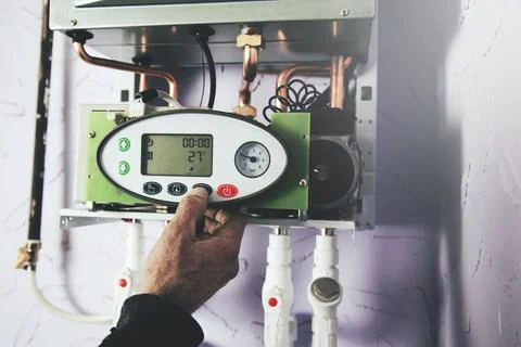 Engineer adjusting thermostat for efficient automated heating system Stock Photos