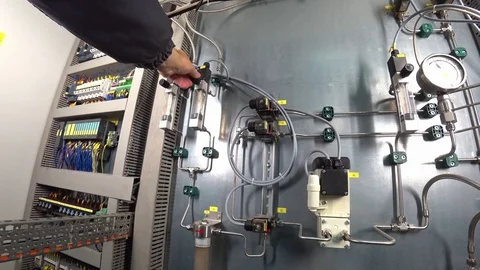 Engineer adjusts the gas flow rate in control cabinet of gas analyzer system. Stock Footage 82470238