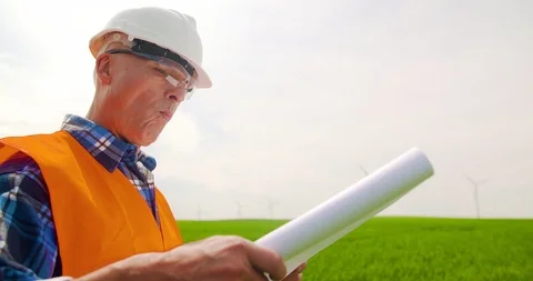 Engineer Analyzing Plan While Standing In Windmill Farm Stock Footage 90968108
