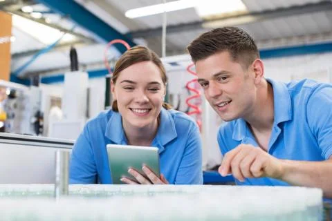 Engineer And Apprentice With Digital Tablet Working In Bottle Capping Factory Foto stock