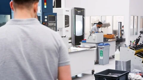 Engineer And Apprentice Discuss Plans On Floor Of Engineering Workshop Video stock 95508826