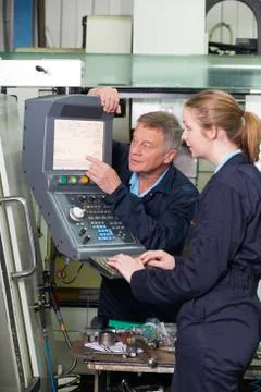 Engineer And Apprentice Using Computerized Cutting Machine 库存照片