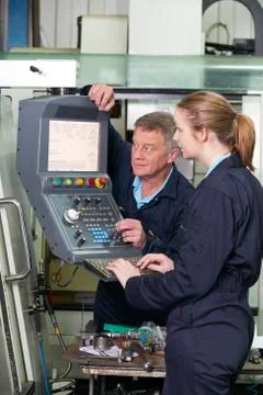 Engineer And Apprentice Using Computerized Cutting Machine 库存照片