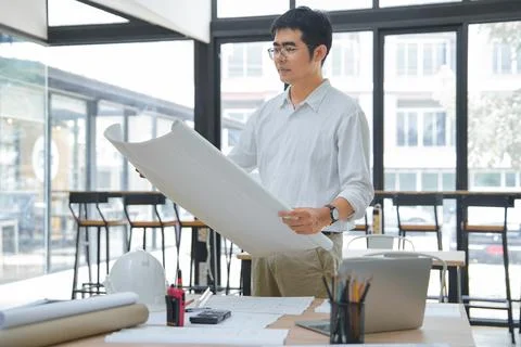 Engineer and Architect Discussing Interior Design Plans in Modern Workspace 스톡 사진