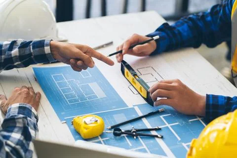 Engineer and Architect meeting working and pointing at a drawings in office.. Stock Photos