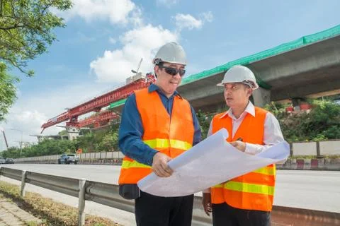 Engineer and Architect or Foreman wear white hardhat and Glow safety cloth me Stock Photos