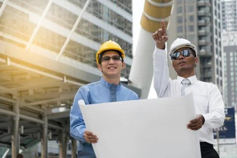 Engineer and Architect working at Construction Site with blueprint Stock Photos