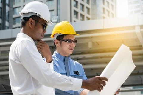 Engineer and Architect working at Construction Site with blueprint Stock Photos
