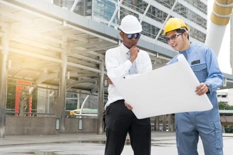 Engineer and Architect working at Construction Site with blueprint Stock Photos