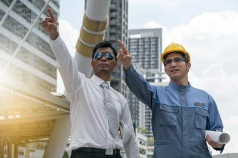 Engineer and Architect working at Construction Site with blueprint Stock Photos