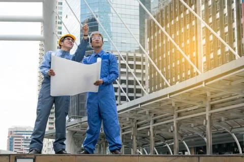 Engineer and Architect working at Construction Site with blueprint Stock Photos