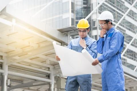 Engineer and Architect working at Construction Site with blueprint Stock Photos