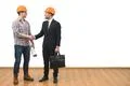 The engineer and a businessman handshake on the white wall background Photo