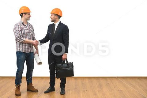 The engineer and a businessman handshake on the white wall background Stock Photos