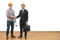 The engineer and a businessman handshake on the white wall background Photo