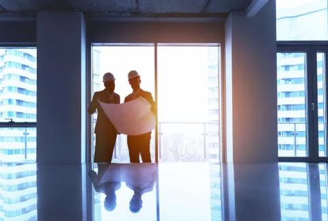 Engineer and businessman with plan in empty office Stock Photos