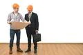 The engineer and a businessman stand with a paper on the white wall backgroun Photo