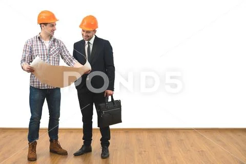 The engineer and a businessman stand with a paper on the white wall backgroun Stock Photos