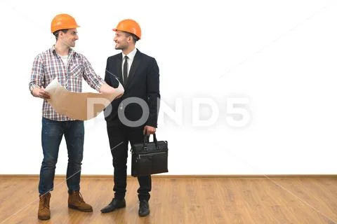 The engineer and a businessman stand with a paper on the white wall backgroun Stock Photos
