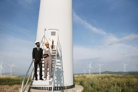 Engineer and businessman using tablet for wok with windmills 스톡 사진