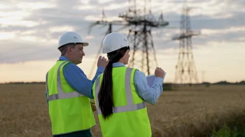 Engineer and colleague with tablet walk to inspect power distribution substation Stock Footage 256288278