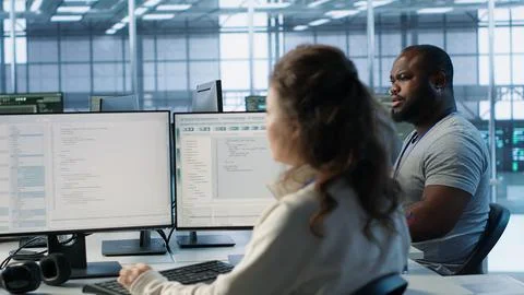 Engineer and colleagues supervising server room infrastructure components Stock Photos