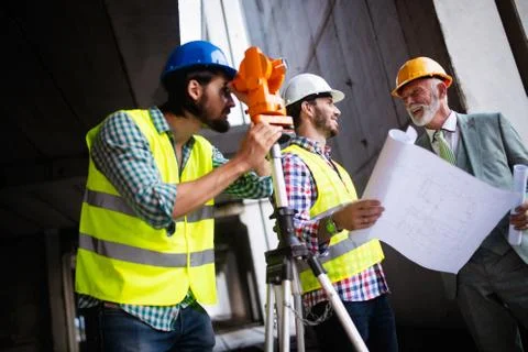Engineer and construction site manager dealing with blueprints and plans Фото