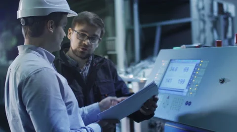 Engineer and Factory Worker are Setting Up CNC Lathe Machine Together. Stock Footage 47913728