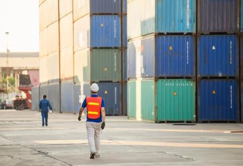Engineer and factory worker team walking in the cargo container 스톡 사진