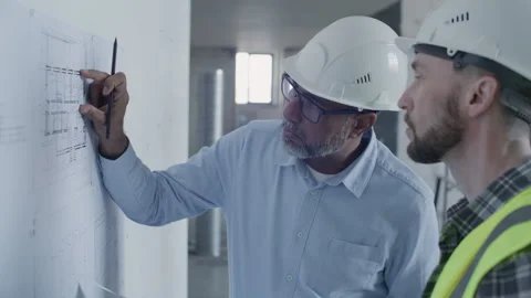 Engineer and Foreman Discussing and Marking Layout Plan at Construction Site Stock Footage 332249459