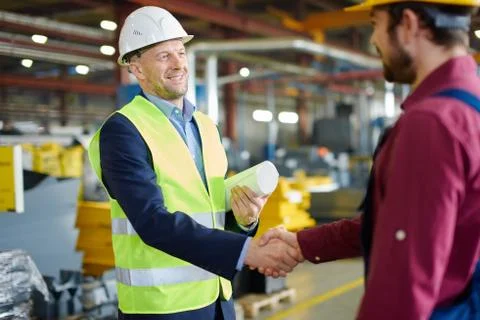 Engineer and foreman shake hands after successfully discussing a new project. Stock Photos