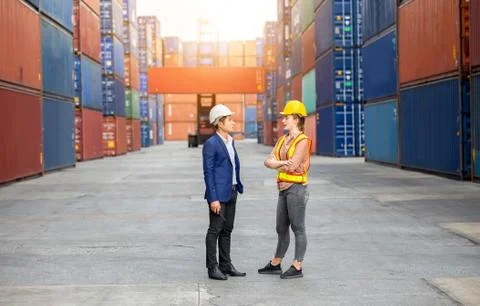 Engineer and foreman worker team control loading containers box at cargo Stockfoto's