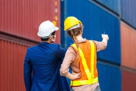 Engineer and foreman worker team checking containers box from cargo Stock Photos