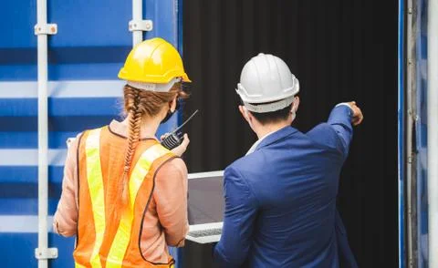 Engineer and foreman worker team checking containers box from cargo Фото