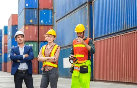Engineer and foreman worker team in hardhat and safety vest at cargo containe 写真素材