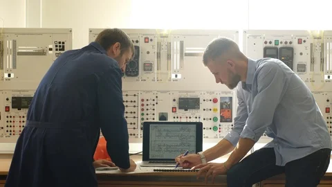 Engineer and foreman working at control room of a modern thermal power plant Stock Footage 70798102